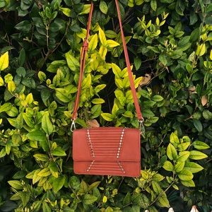 Crossbody bag with gold embellishments.